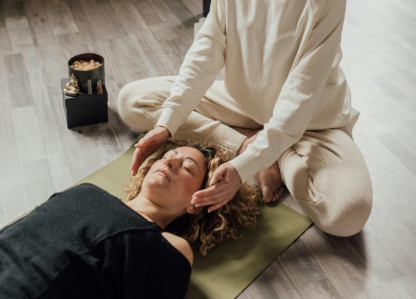 Practitioner holding hands over the head of a person who is resting